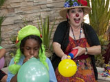 Lollipop the clown entertaining a group of kids making balloon animals.