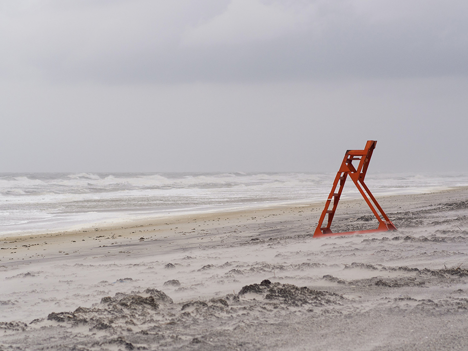a lifeguard chair on an empty beach during a storm