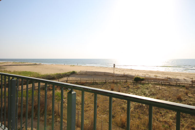 The condo balcony overlooks the beach.