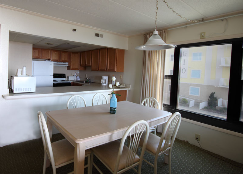 The full size kitchen is visible from the dining room with a bar/counter top acting as a divider.