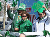 A St Patricks Day parade float with plenty of green and positive people.