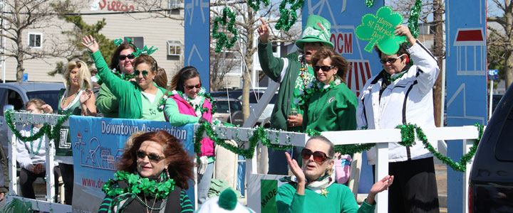 A St Patricks Day parade float with plenty of green and positive people.