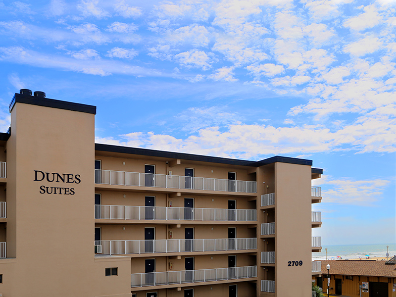 Dunes Suites Ocean City, Maryland building exterior with beach and ocean in background